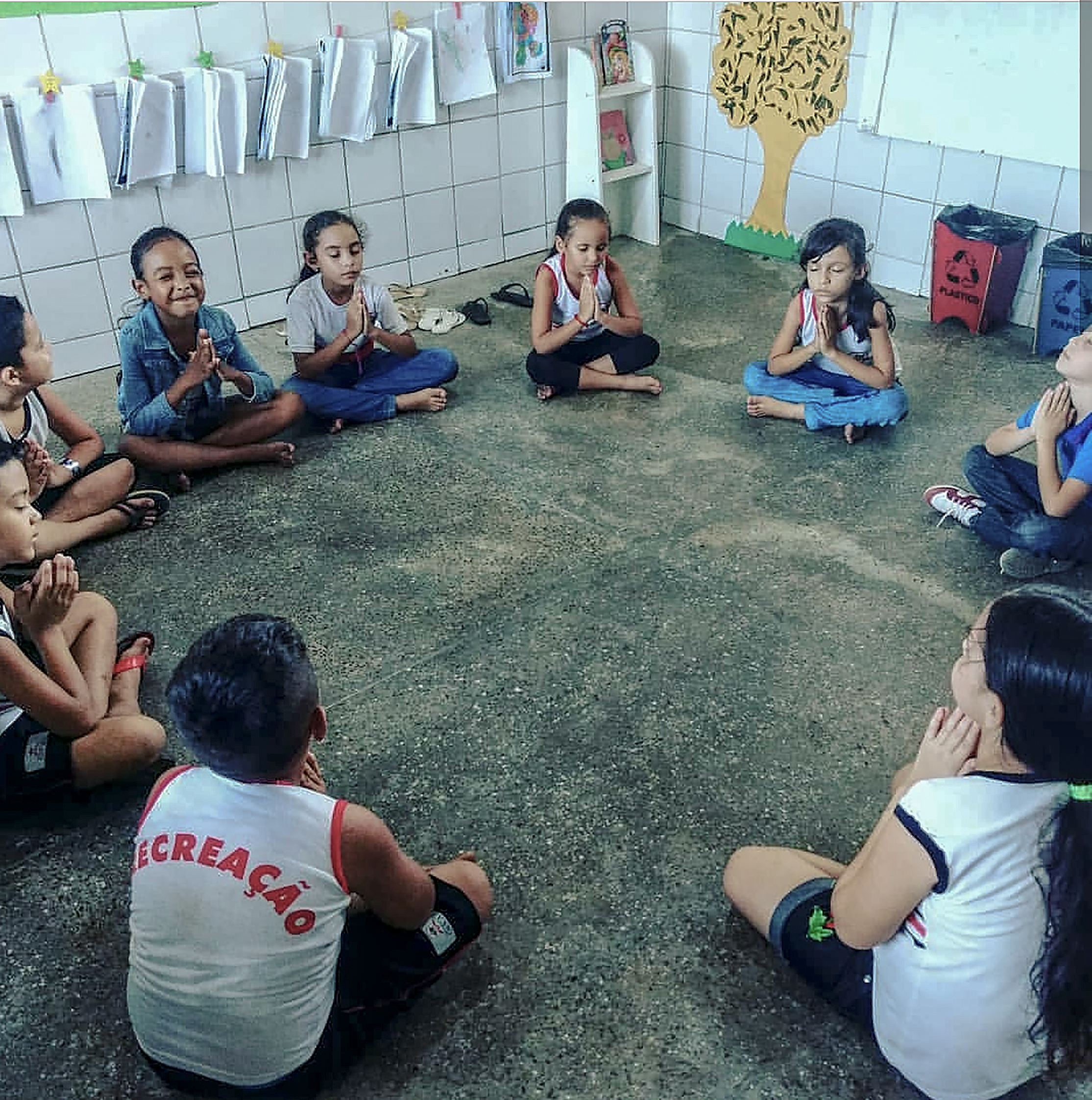 Crianças participando do projeto "Valores Humanos na Educação Infantil", do Instituto Myra Eliane. A técnica de meditação é aplicada antes da aula, com o intuito de aflorar a concentração e a criatividade dos pequenos. (Foto: Reprodução)